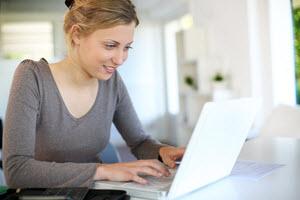 Online course button image shows person on computer smiling